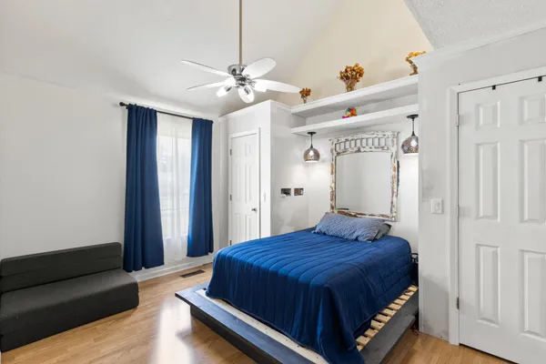 a bedroom with a bed and wooden floor