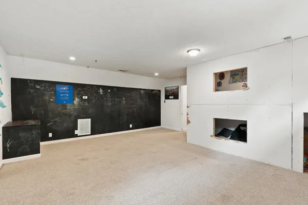 a large white kitchen with granite countertop a fireplace