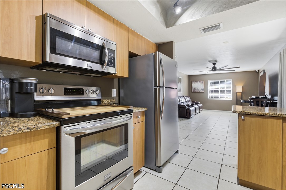 4960 20th Place Southwest Naples, FL 34116 - Photo 11 of 33 a kitchen with stainless steel appliances granite countertop a stove a microwave and a refrigerator