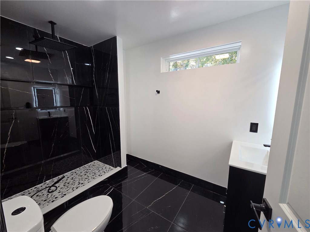 2420 Yarnell Road Henrico, VA 23231 - Photo 17 of 25 a bathroom with a sink a toilet a mirror and vanity