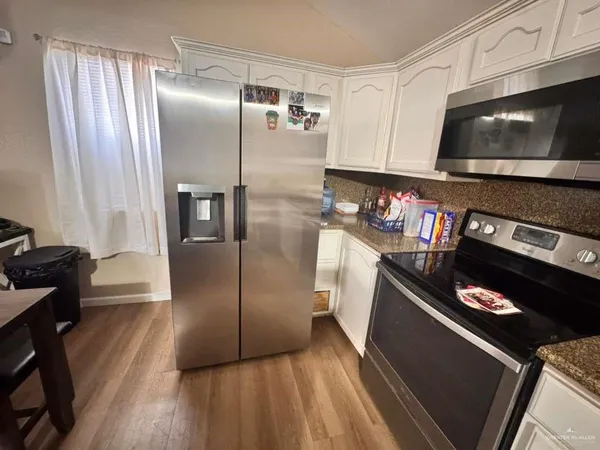 a kitchen with stainless steel appliances granite countertop a refrigerator and a stove top oven