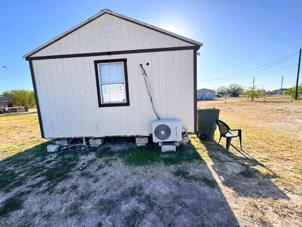 a backyard of a house with wooden fence next to a yard