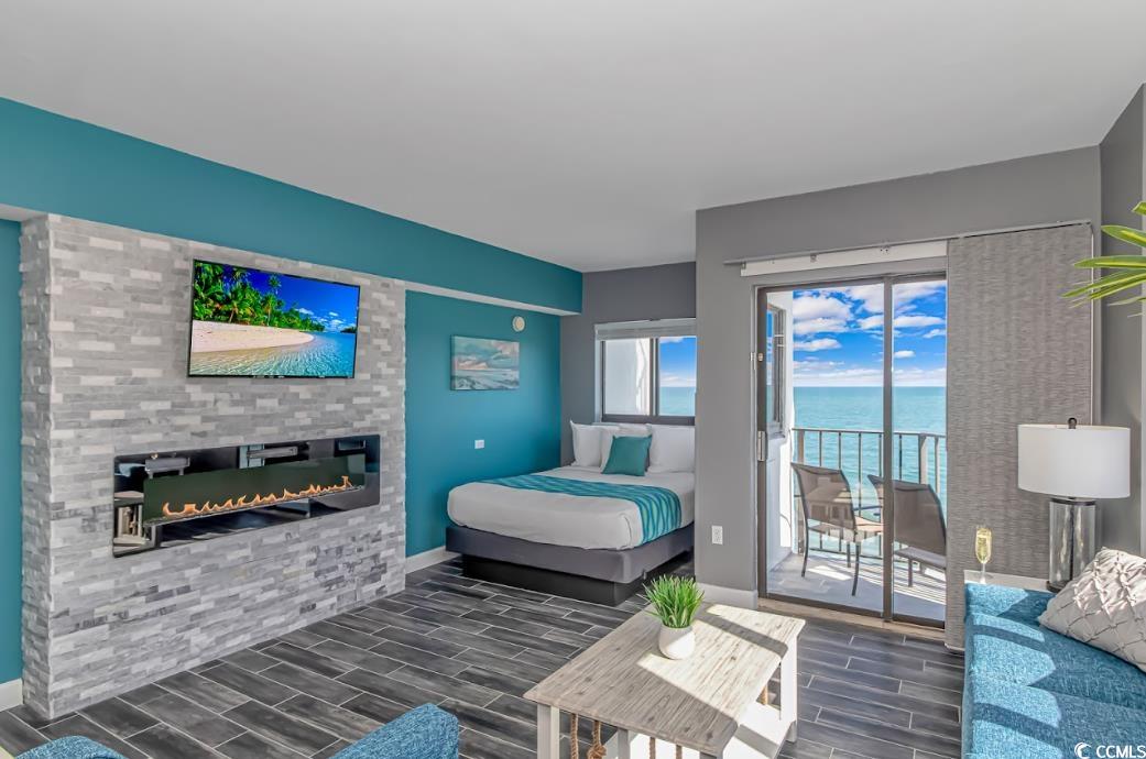 1605 South Ocean Boulevard, Unit 603 Myrtle Beach, SC 29577 - Photo 11 of 40 Bedroom featuring a fireplace, wood tiled floors, and access to exterior