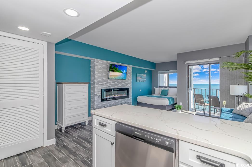 1605 South Ocean Boulevard, Unit 603 Myrtle Beach, SC 29577 - Photo 40 of 40 Kitchen featuring open floor plan, a fireplace, stainless steel dishwasher, light stone counters, and recessed lighting