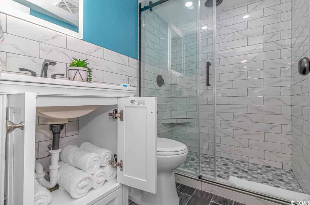 1605 South Ocean Boulevard, Unit 603 Myrtle Beach, SC 29577 - Photo 20 of 40 Bathroom with tile walls and a shower stall