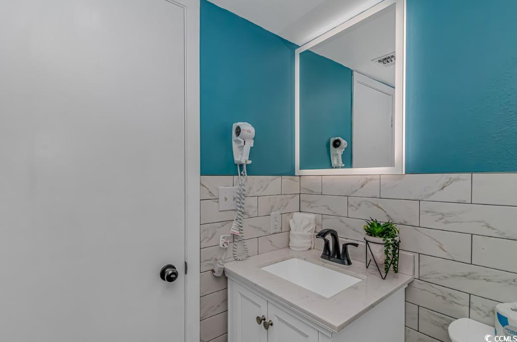 1605 South Ocean Boulevard, Unit 603 Myrtle Beach, SC 29577 - Photo 22 of 40 Half bath with vanity and tile walls