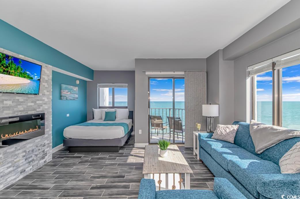 1605 South Ocean Boulevard, Unit 603 Myrtle Beach, SC 29577 - Photo 3 of 40 Bedroom featuring a water view, a glass covered fireplace, wood finish floors, and multiple windows