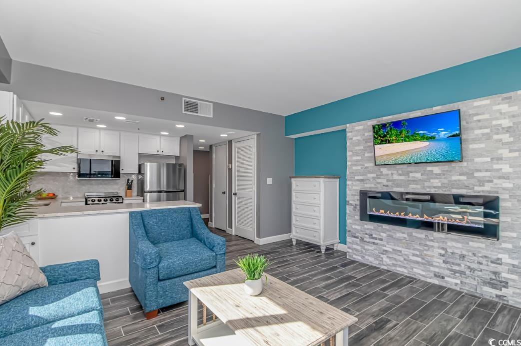1605 South Ocean Boulevard, Unit 603 Myrtle Beach, SC 29577 - Photo 7 of 40 Living room with wood finish floors, a glass covered fireplace, and recessed lighting