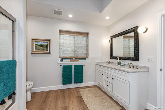 a bathroom with a double vanity sink toilet and a mirror