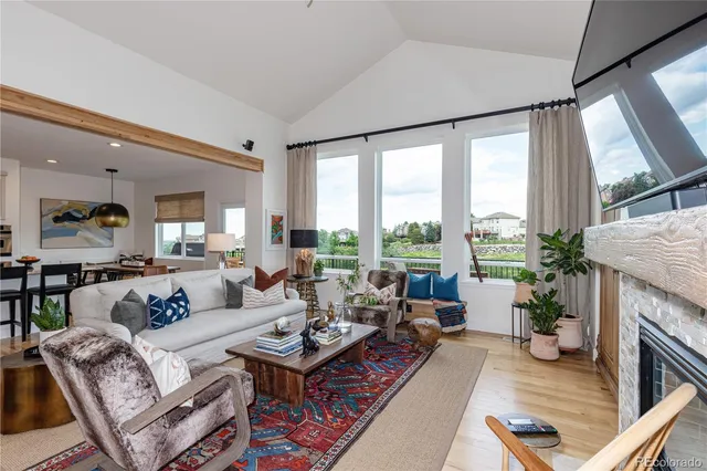 a living room with fireplace furniture and a large window