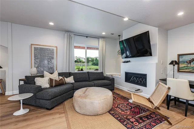 a living room with furniture a flat screen tv and a fireplace