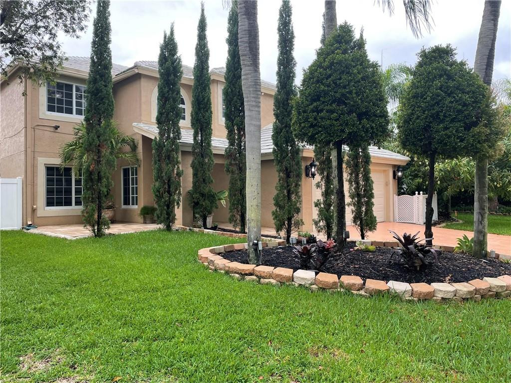 22909 Old Inlet Bridge Drive Boca Raton, FL 33433 - Photo 1 of 9 a front view of a house with a garden
