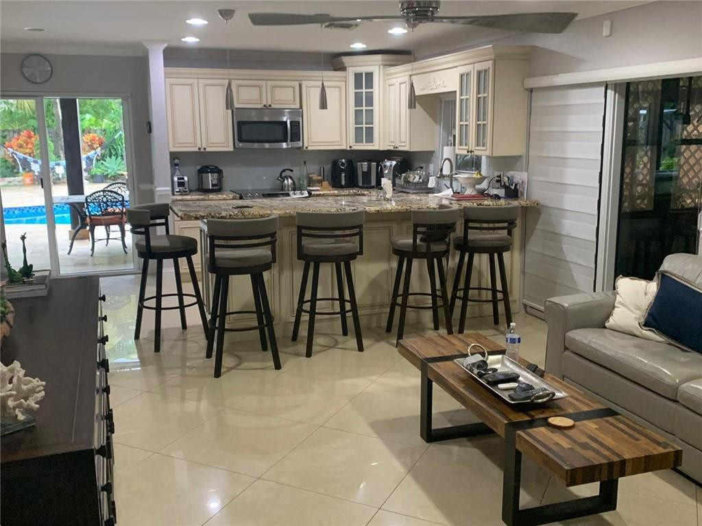22909 Old Inlet Bridge Drive Boca Raton, FL 33433 - Photo 3 of 9 a kitchen with a table chairs stove and cabinets