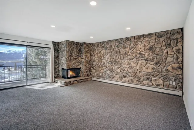 an empty room with a fireplace and large window