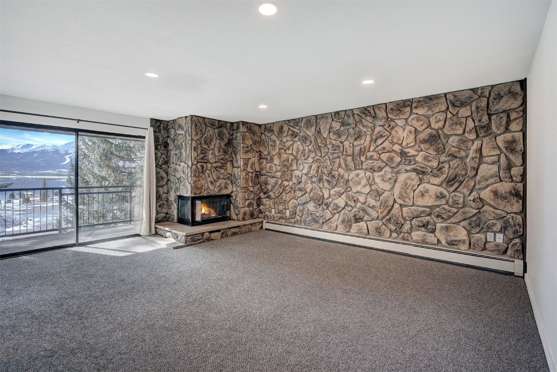 an empty room with a fireplace and large window