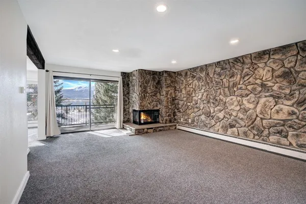 an empty room with a fireplace and large window