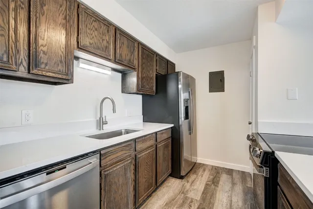 a kitchen with stainless steel appliances a sink and a refrigerator