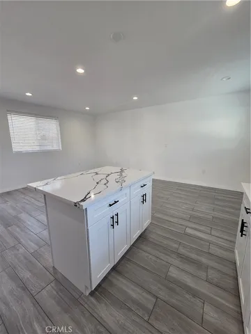 a kitchen with stainless steel appliances wooden cabinets and wooden floor