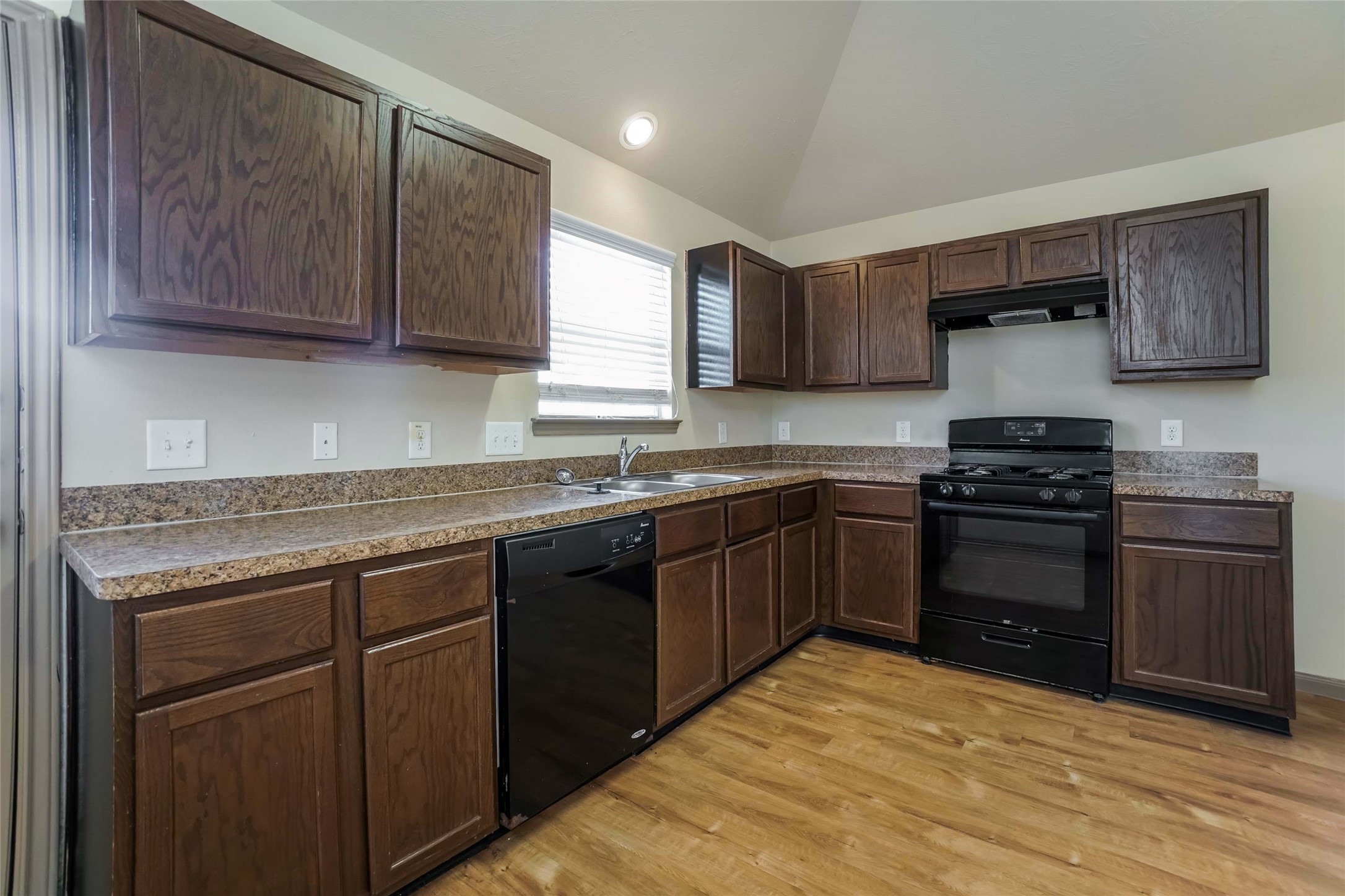 a kitchen with stainless steel appliances granite countertop a stove a sink and a refrigerator