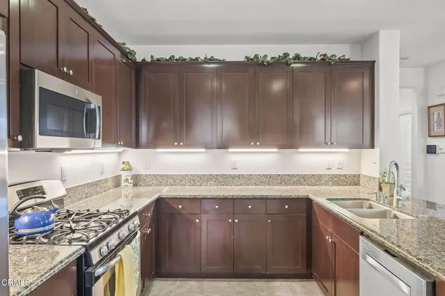a open kitchen with stainless steel appliances granite countertop a sink and cabinets