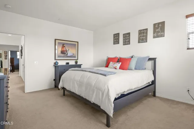 a bedroom with a bed and a painting on the wall