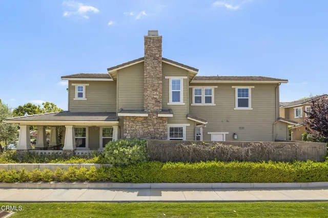 a view of a house with brick walls and flower plants