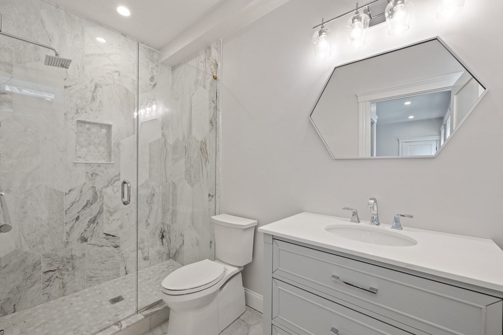 21 Alpha Road, Unit 1 Boston, MA 02124 - Photo 13 of 24 a bathroom with a sink a toilet and a mirror