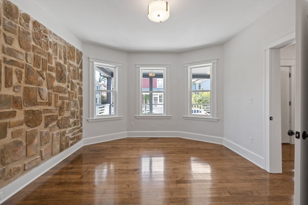21 Alpha Road, Unit 1 Boston, MA 02124 - Photo 17 of 24 a view of an empty room with a window and wooden floor