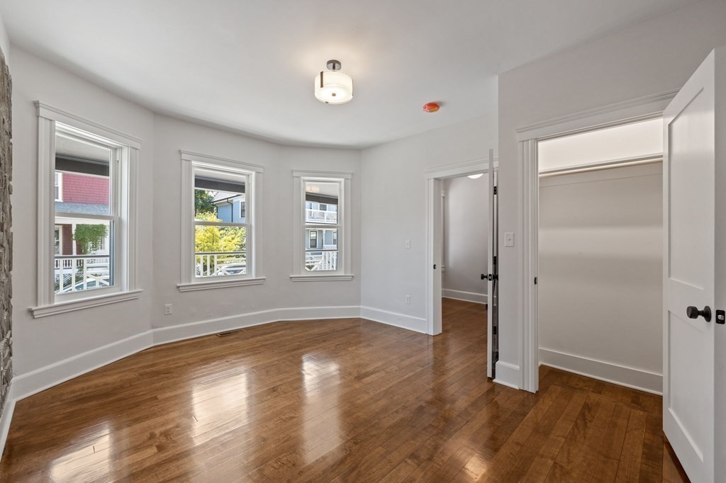 21 Alpha Road, Unit 1 Boston, MA 02124 - Photo 18 of 24 an empty room with window and wooden floor