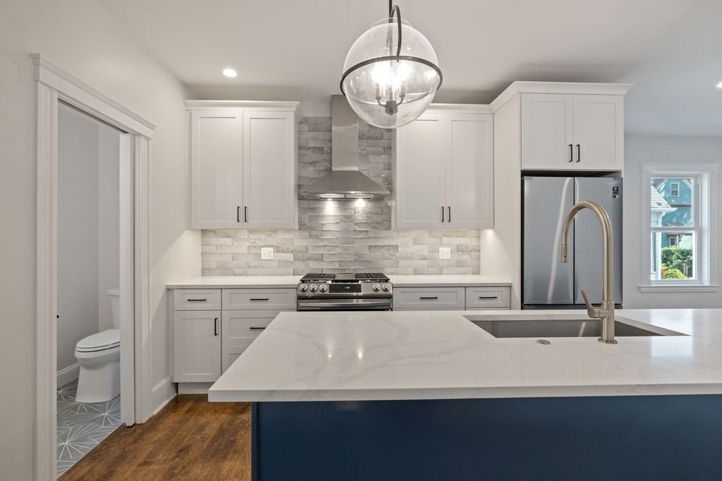 21 Alpha Road, Unit 1 Boston, MA 02124 - Photo 7 of 24 a kitchen with stainless steel appliances a sink stove and refrigerator