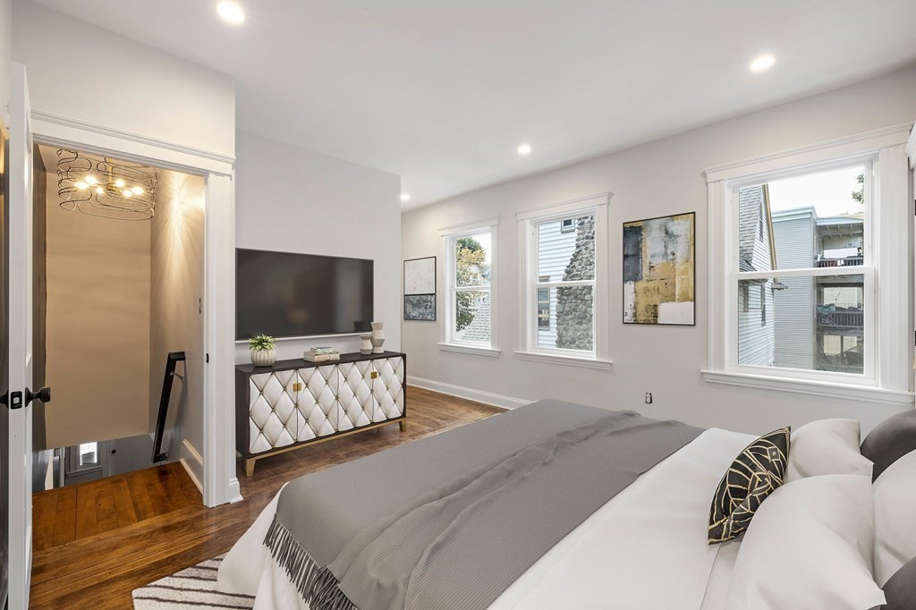 21 Alpha Road, Unit 1 Boston, MA 02124 - Photo 9 of 24 a bedroom with a bed and a flat screen television