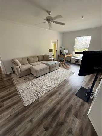 a living room with furniture and a wooden floor