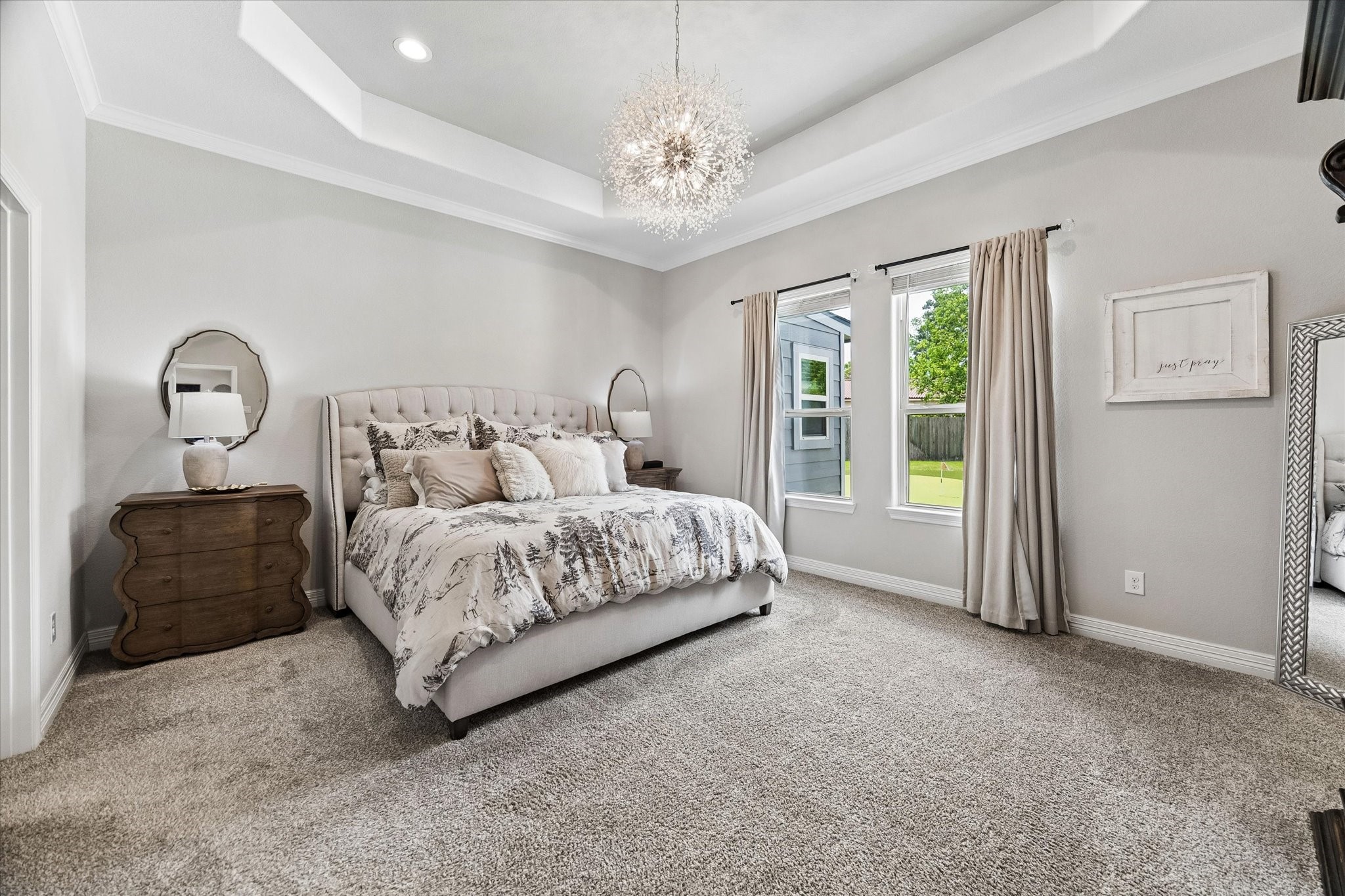 5935 Dovershire Knoll Court Spring, TX 77389 - Photo 16 of 34 a bedroom with a large bed and a chandelier