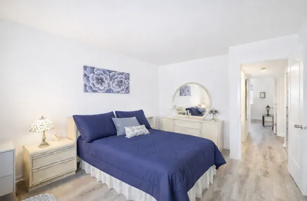 a bedroom with a large bed and a chandelier