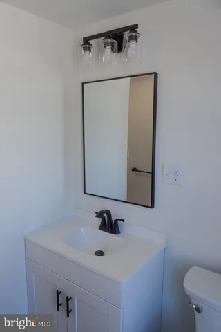 a bathroom with a sink a toilet and mirror