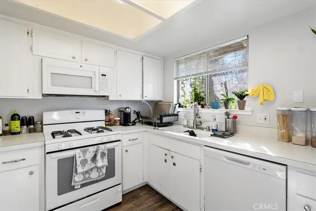 a kitchen with white cabinets and white appliances