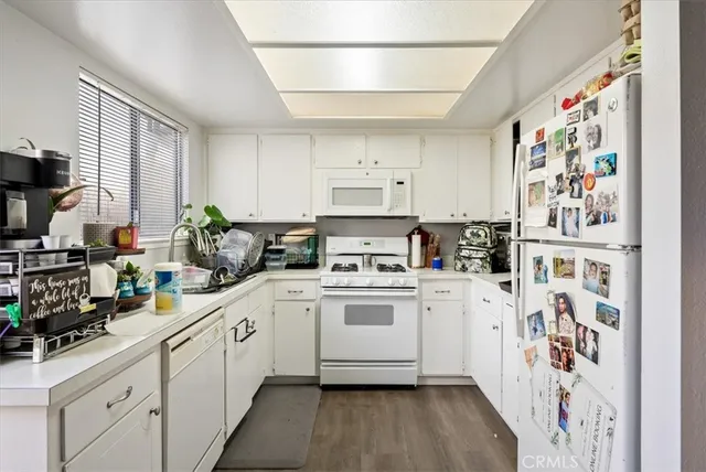 a kitchen with stainless steel appliances a refrigerator sink and white cabinets