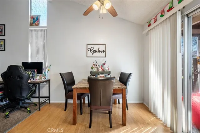 a bedroom with a bed a computer on the desk and a window