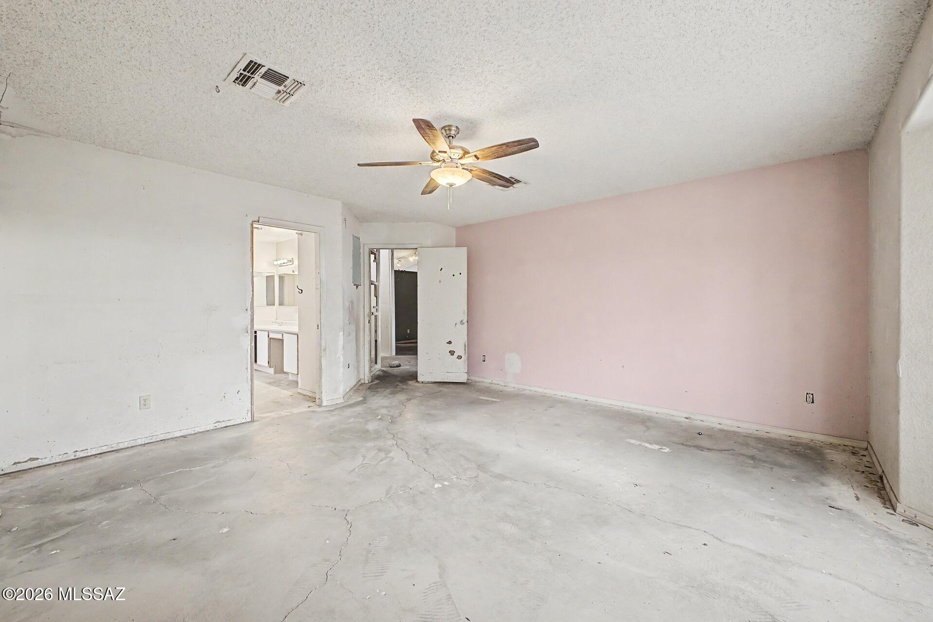 9810 East Stonehaven Way Tucson, AZ 85747 - Photo 16 of 27 an empty room with closet and a ceiling fan