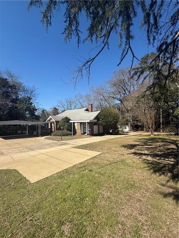 2808 Summerville Road Phenix City, AL 36867 - Photo 15 of 15 View of green lawn featuring concrete driveway, a carport, and an attached garage