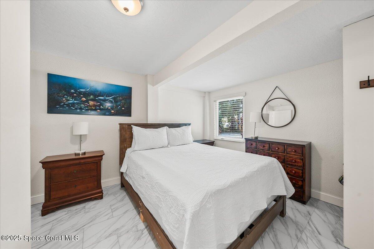 111 South Atlantic Avenue Cocoa Beach, FL 32931 - Photo 13 of 71 a bedroom with bed and a painting on the wall