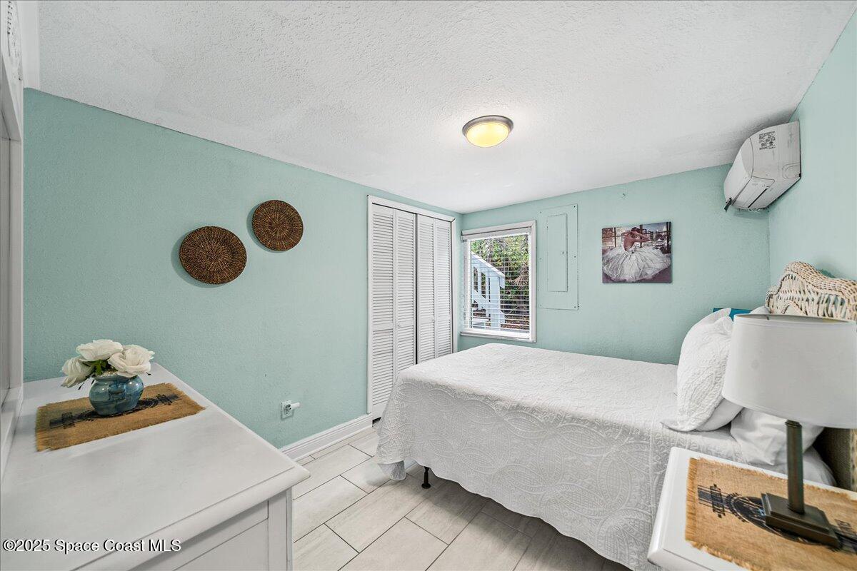 111 South Atlantic Avenue Cocoa Beach, FL 32931 - Photo 25 of 71 a bedroom with a bed and painting on the wall