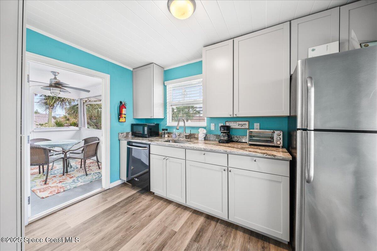 111 South Atlantic Avenue Cocoa Beach, FL 32931 - Photo 31 of 71 a kitchen with stainless steel appliances a refrigerator sink and cabinets