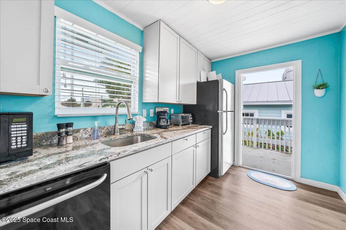 111 South Atlantic Avenue Cocoa Beach, FL 32931 - Photo 34 of 71 a kitchen with granite countertop a refrigerator and a sink