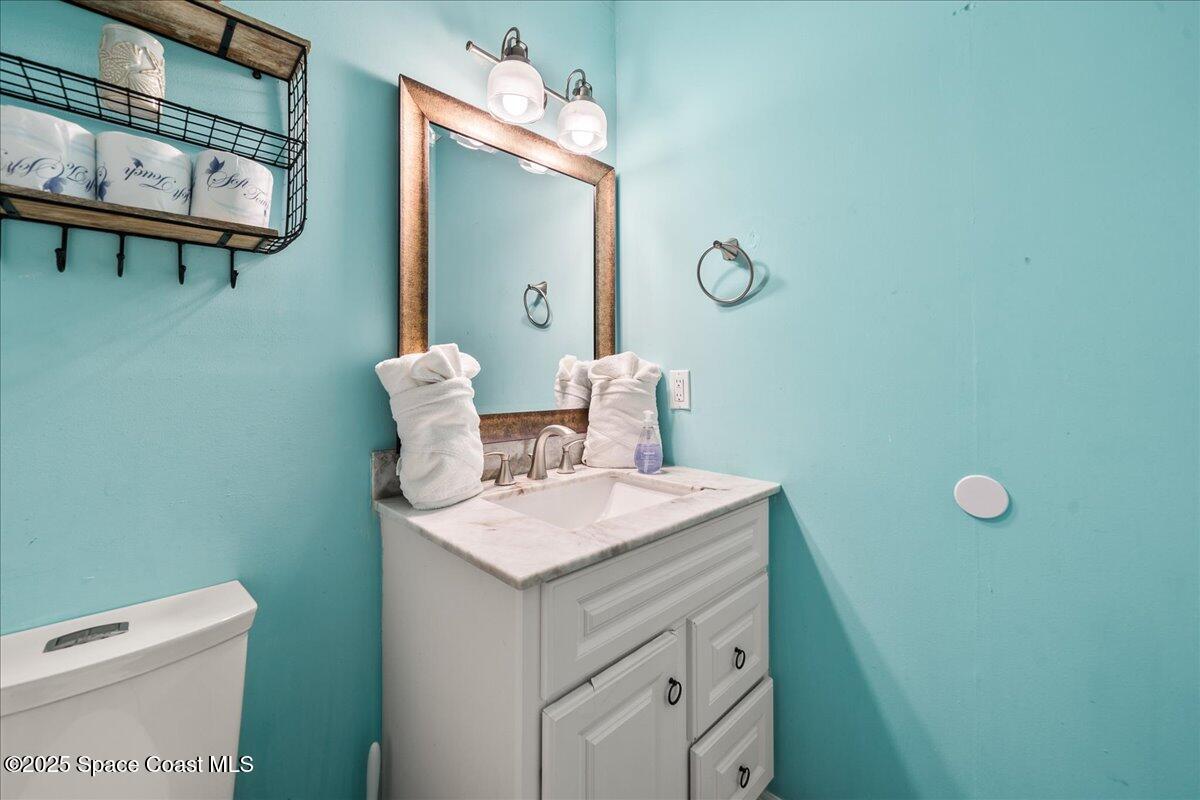 111 South Atlantic Avenue Cocoa Beach, FL 32931 - Photo 36 of 71 a bathroom with a sink a toilet and mirror