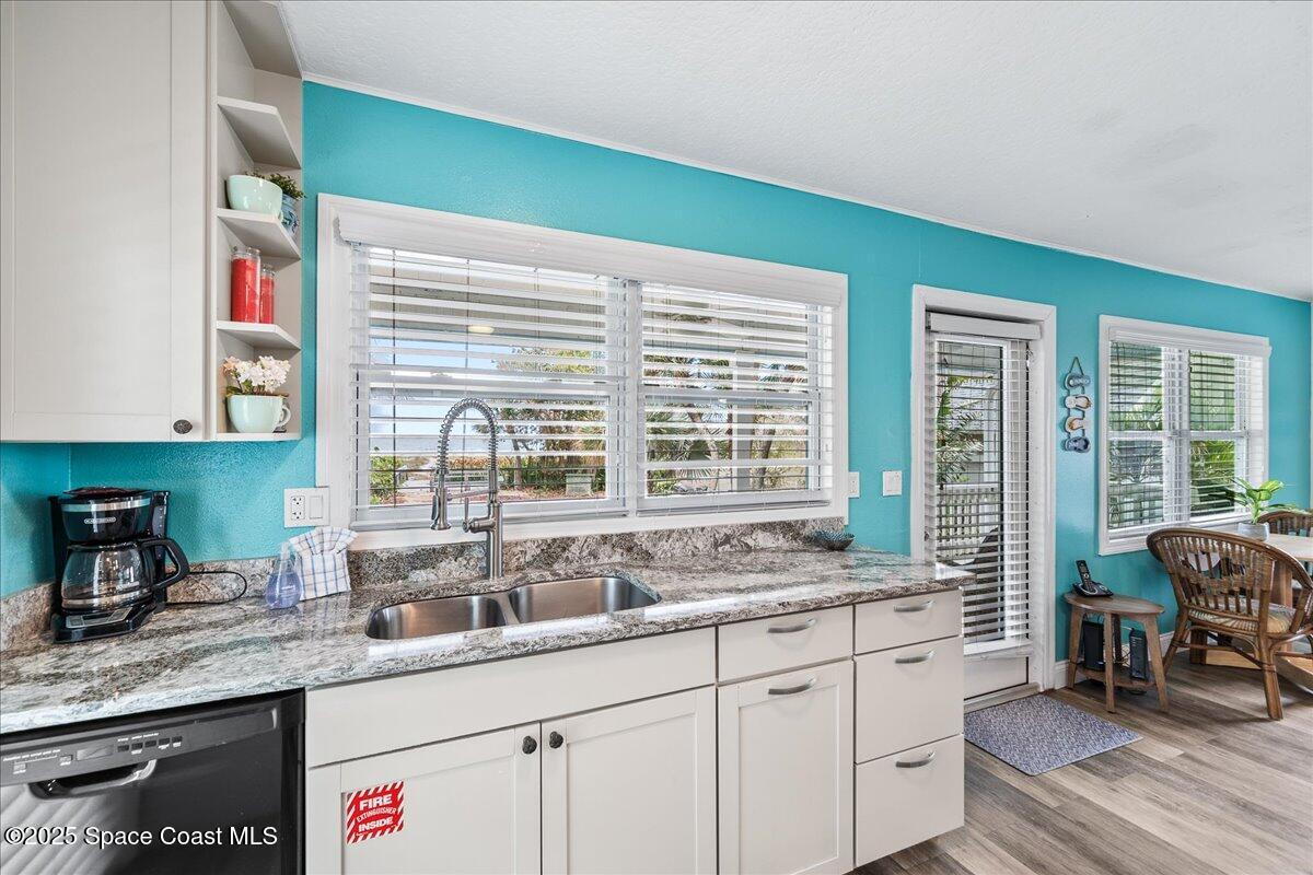 111 South Atlantic Avenue Cocoa Beach, FL 32931 - Photo 43 of 71 a kitchen with granite countertop a sink and a large window