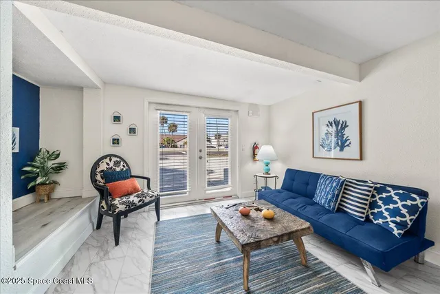 a living room with granite countertop lots of white furniture and wooden floor