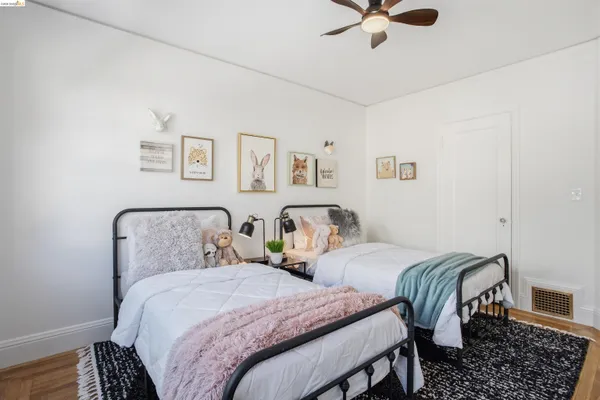 a bedroom with two beds and painting on the wall