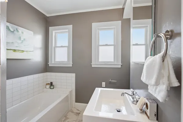 a bathroom with a sink a bathtub and a window