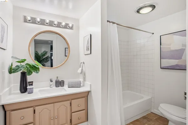 a bathroom with a granite countertop sink a mirror a vanity and bathtub